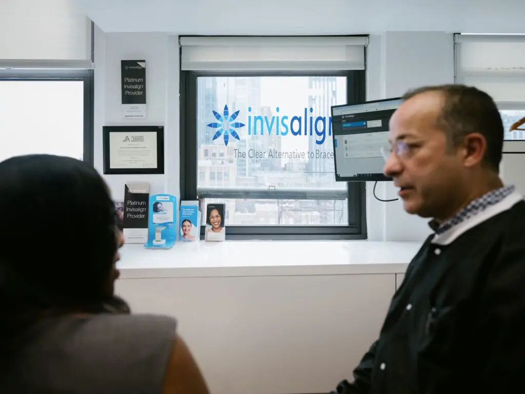 a man and woman sitting in front of a window with the invisalign logo
