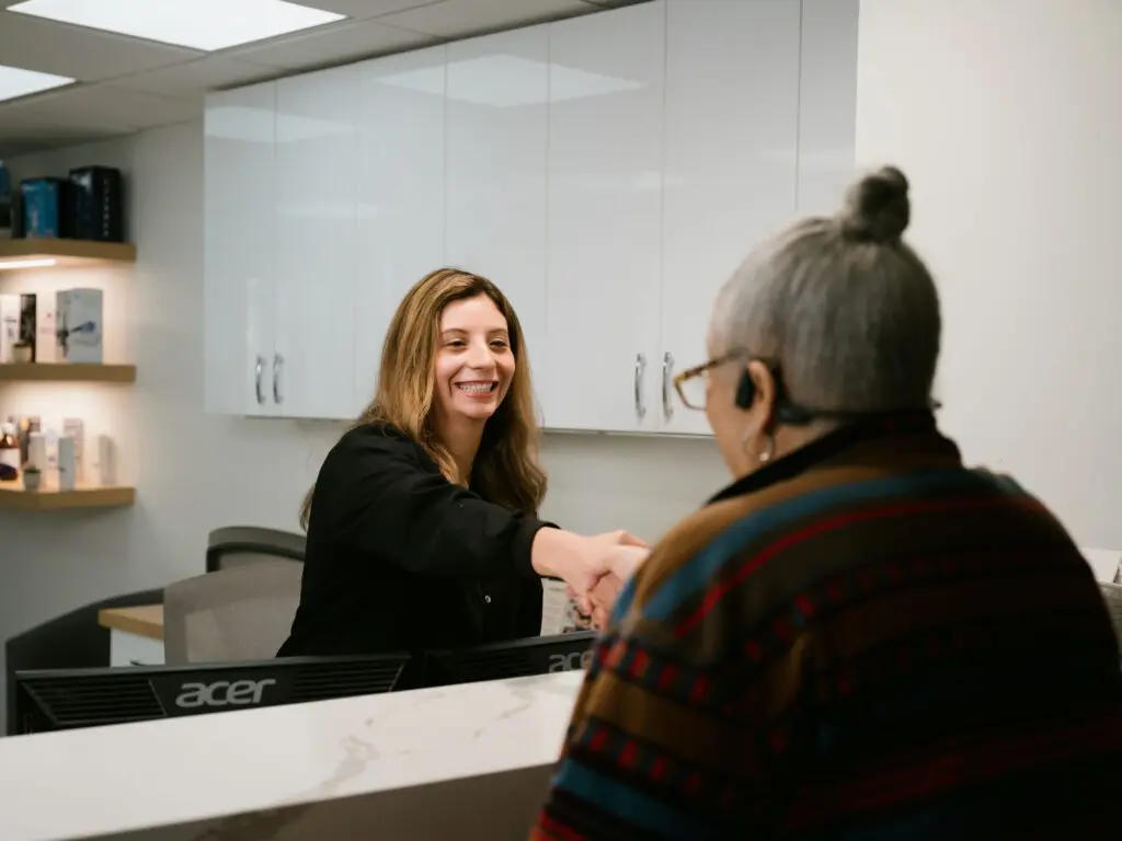 a woman shaking hands with an old woman