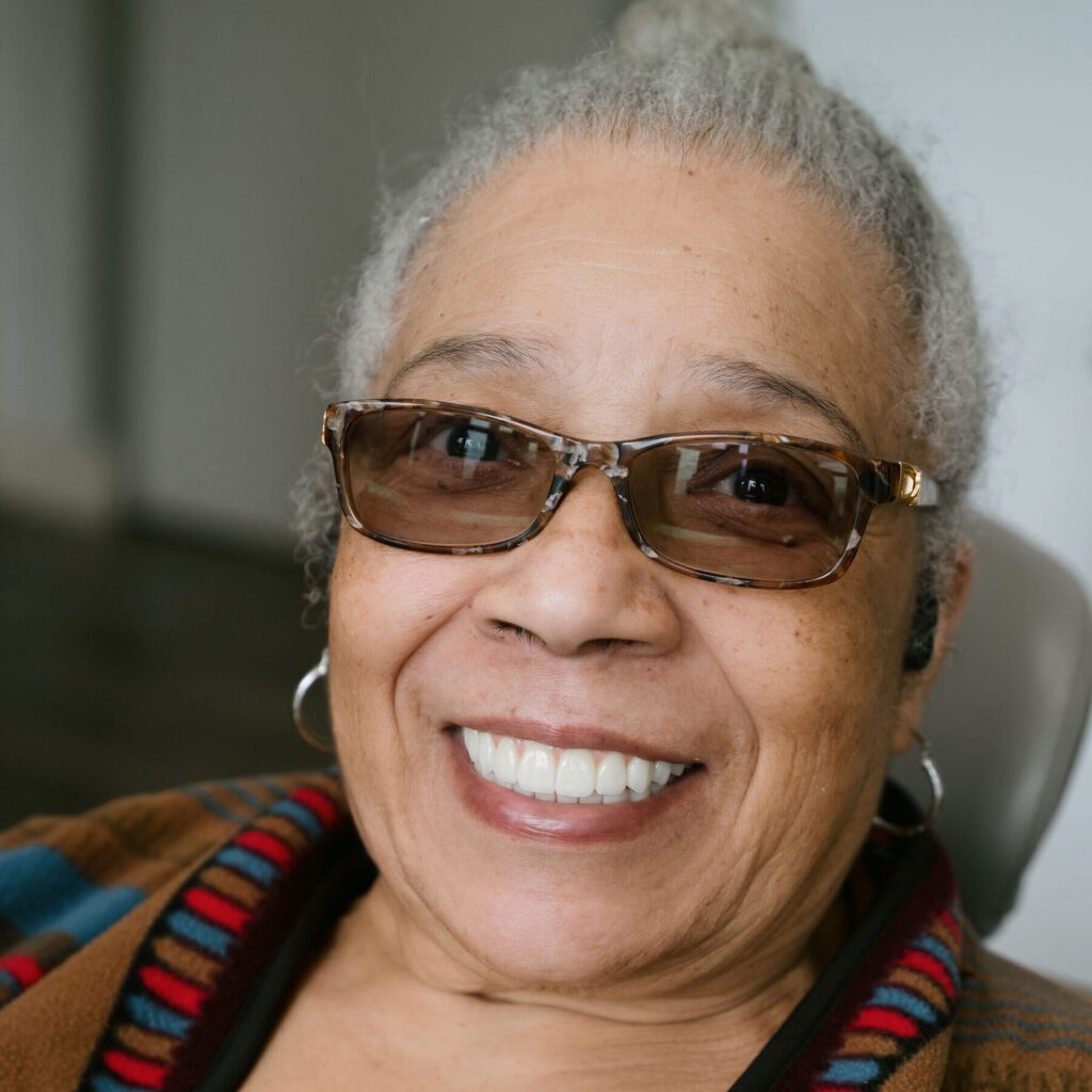 a woman wearing glasses and smiling